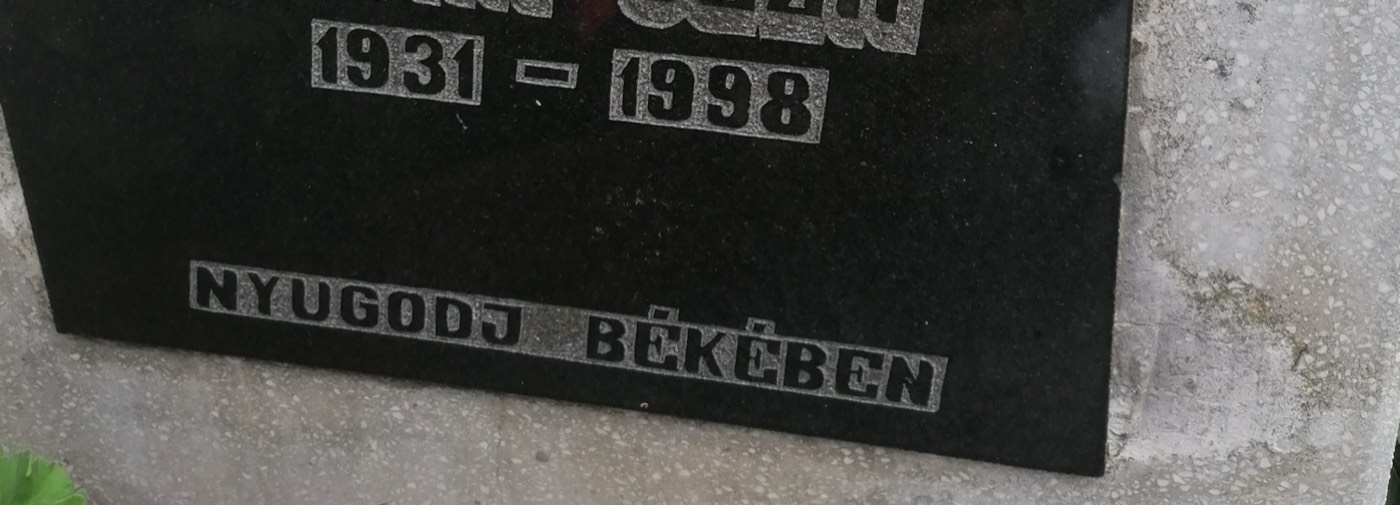 Vésett évszám és felirat egy fekete gránit síremléktáblán